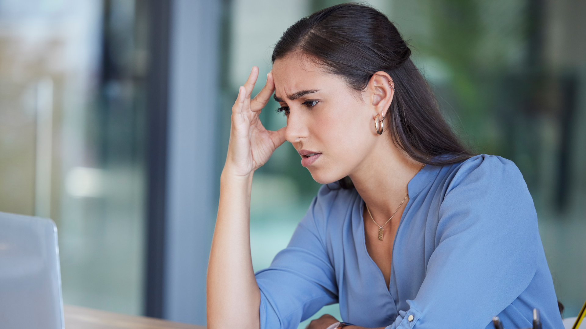 femme qui se tient la tête devant son ordinateur